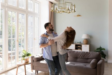 Mutlu yakışıklı adam sosyal dans öğretiyor, heyecanlı kız arkadaşı eğitiyor, sarılma partneri, oturma odasında dönüyor. Neşeli dansçılar evde eğleniyor, eğleniyor, parti veriyor, yıldönümlerini kutluyorlar.