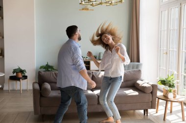 Güzel kız arkadaşın evde dans etmeyi öğretiyor. Neşeli aktif çift apartmanın içinde eğleniyor, dans eğitimi alıyor, müzik yapıyor, gülüyor. Aşk, ilişki ev eğlencesi konsepti