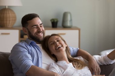 Rahat, mutlu sevgili bir çift kanepede dinleniyor, boş zamanların, yakınlığın, konuşmanın, konuşmanın, gülmenin, sarılmanın tadını çıkarıyor. İlişki, evlilik, birlikte yaşama kavramı.