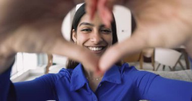 Mutlu yüzleri kapatın, çeşitli etnik çeşitlilikteki genç ve yaşlı insanların portrelerini değiştirin ve kameraya kalp sembolü gösterin. Seni seviyorum işaret, kültürler ve nesiller arası insan bağı, insanlığı paylaş.