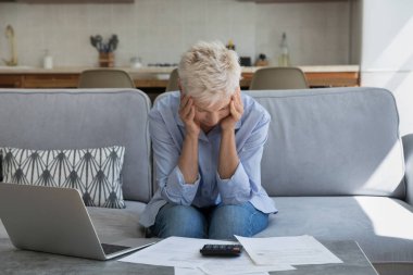 Stresli, yaşlı, emekli bir kadın ofis sarılma koltuğunda oturur depresyondaki baş elektrik faturalarını ödeyemez ve yüksek vergi oranlarıyla şok olur. Sorunlu yaşlı kadın maddi sorunları var.