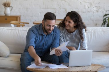 Mutlu 30 'lu yaşlardaki kiracılar, ev sahipleri ev işleri, ev işleri, evrak işleri, dizüstü bilgisayardaki kağıt dökümanların incelenmesi, hesap makinesi, faturalar, ipotek, internet kiraları.