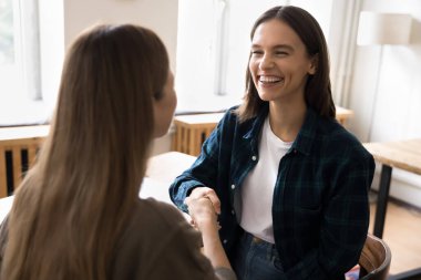 İki genç iş kadını şirket ofisinde el sıkışırken, anlaşma jesti, verimli toplantı veya tartışmanın sonucu, karar veya proje konusunda karşılıklı anlaşmaya vardı. İnsan Kaynakları, işe alım
