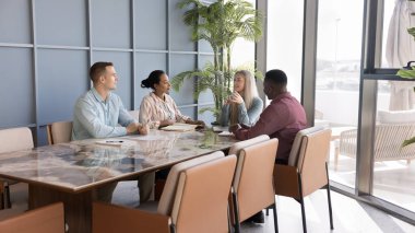 Toplantı masasında konuşan, yaratıcı proje üzerine beyin fırtınası yapan, başlangıç için fikirleri tartışan çok ırklı iş adamlarından oluşan bir ekip. Beyaz kadın patron lider koltuğunda konuşuyor.