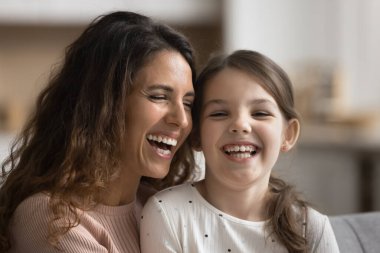 Güzel genç bir kadının ve güzel bir kızın mutlu yüzlerini kapatın, gülümseyin, gülün, beyaz dişleri gösterin, dişçi kliniği reklamları yapın. Annelik, yetiştirilme, aile bağları ve sevgi, portre