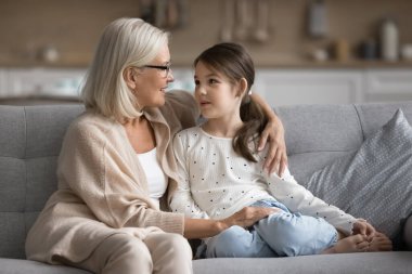 Sevgi dolu, olgun bir büyükanne anaokulu öğrencisi olan 6 yaşındaki tatlı torunuyla hoş sohbetler yapıyor. Kanepede dinlenirken sarılıyor, özen gösteriyor, desteğini paylaşıyor, aşkı hissediyor.