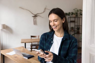 25 'lerinde genç bir kadın ofisinde akıllı telefon kullanıyor, iyi haberlerle mesaj okuyor ya da tebligat yapıyor, sosyal medyada geziniyor, güncelleme alıyor, mesaj gönderiyor ya da arkadaşa cevap veriyor. Mobil uygulamalar, teknik kullanım