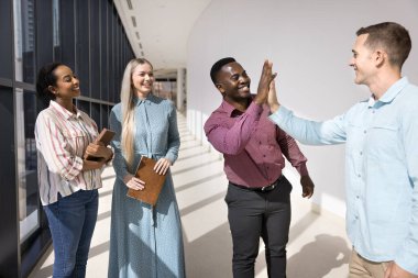 Ofisteki çeşitli erkek iş arkadaşlarıyla buluşup beşlik çakıyor, gülümsüyor, gülüyor ve eğleniyorlar. Afrikalı ve Kafkas işadamları arkadaşlığın tadını çıkarıyor, başarılı takım çalışması