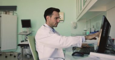 Olgun pratisyen hekim masada oturup bilgisayardan kötü haberler okuyor, kritik test sonuçları, tıbbi rapordaki hata veya PC kullanımı ile ilgili sorunlar, negatif hasta geri bildirimi veya şikayetler nedeniyle stresli ve endişeli hissediyor