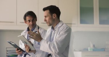 İki 40 'lı yılların İspanyol terapisti hasta teşhisi, planlama tedavisi seçeneğini tartışıyor, fikir ve deneyimleri paylaşıyor, anestezi veya tablet üzerindeki tanısal laboratuvar görüntülerini gözden geçiriyorlar.