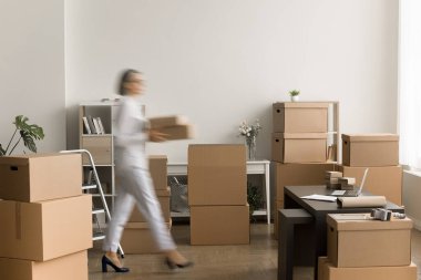 Olgun bir iş sahibinin karton kutular taşıdığı, depoda yürüdüğü e-ticaret internet mağazası deposunda çalıştığı, lojistik işler yaptığı bulanık bir kare. Hareket bulanıklığı