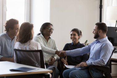 Beş etnik çeşitlilikte iş adamı iş yerinde el sıkışıyor ya da resmi toplantılara katılıyor. Kar anlaşması yap, işbirliğine, güvene, saygı jestine, iş konseptine şükranlarını sun.