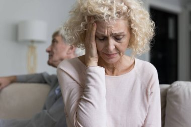 Stresli, orta yaşlı bir eş ihtilaftan sonra ağlıyor, kocasıyla tartışıyor, adamı görmezden geliyor, sessizliğini koruyor, kafasına dokunuyor, baş ağrısı, umutsuzluk, sorunlardan bıkıyor, aile içi şiddet uyguluyor.