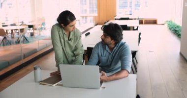 İki profesyonel modern ofiste dizüstü bilgisayarda proje stratejisini tartışıyor. İş adamları veri analizi ve işbirliğine odaklandı fikirleri paylaştı, ticari büyüme ve başarı için mali çözümler planladı