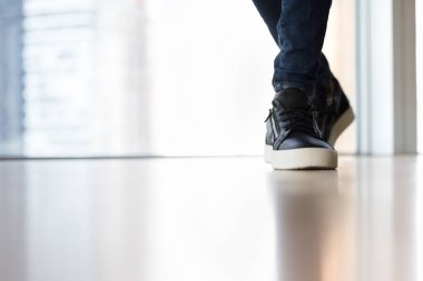 Erkek ayağında modaya uygun ayakkabı fotokopi alanı ile yakın çekim. Parlak zeminde dans eden dansçı bacakları, aktivite çalışmaları, ergonomik spor ayakkabıları, spor ayakkabıları.