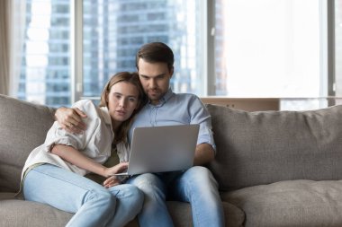 Milenyum çifti internetten alışveriş yapıyor, modern oturma odasındaki rahat koltukta dizüstü bilgisayarla dinleniyor, hediyeler seçiyor, bilet alıyor, otel ayırtıyor, tatil planları yapıyor. E-servis müşterileri, teknoloji