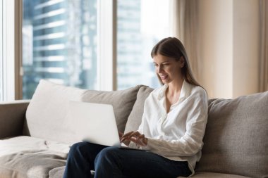 Kablosuz teknoloji için dizüstü bilgisayar kullanan, yurtiçi internet iletişimi kuran, bilgisayar başında çalışan, daktilo kullanan, sohbet eden, online iş servisini kullanan pozitif milenyum kızı.