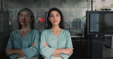 Güzel Latin iş kadını portresi, şirket sahibi ya da çalışanı çağdaş ofiste duruyor, kameraya neşeli bir ifadeyle bakıyor iş sonuçlarından ve profesyonel büyümeden tatmin oluyor.