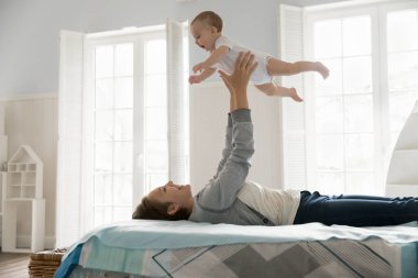 Hayali uçuş. Tasasız, mutlu, genç bir anne, hafif yatak odasında sevimli bir bebekle etkileşim içinde. Yatakta sırt üstü uzanıp, tutarak gülüyor, kollarını açıp, oyun zamanı eğleniyor. Boşluğu kopyala