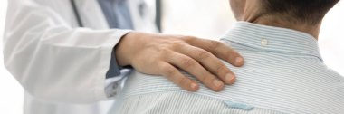 Şefkatli bir doktorun eli omzuna ve sırtında ciddi bir teşhis ve sağlık sorunu olan bir adamın omzuna dokunuyor. Umut ve terapi için hastaları cesaretlendiren bir tıp uzmanı. Kırpılmış afiş atışı