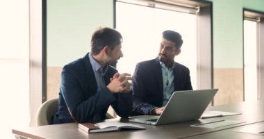 Çok ırklı iş ortakları online proje, uygulama ürünü, dizüstü bilgisayarda başlangıç sunumu, bilgisayardaki ofis toplantısı masasında konuşma, ortaklık için yaratıcı fikirleri tartışırlar.