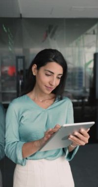 Gülümseyen iş kadını, iş yerinde tablet üzerinde çalışan şirket çalışanı, sohbet eden, e-postaları kontrol eden, iş mektuplarına cevap veren, müşteriyle yazışırken tatmin olan, yeni uygulamayı gözden geçiren.