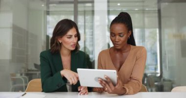 Dijital tablet kullanarak sunum üzerinde çalışan iki genç bayan iş arkadaşı, aygıt ekranına bakın, verileri tartışın, yeni yazılımı gözden geçirin, fikirleri paylaşın, üretken takım çalışmasına bağlı işle ilgili sorunları çözün
