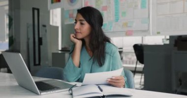 İşine odaklanmış Latin bir kadın, ofis çalışanı, kişisel ajandasında notlar alıyor, kağıt bilgilerini analiz ediyor, modern işyerindeki masada oturan dizüstü bilgisayarla evrak işleriyle uğraşıyor. Çalışma Akışı