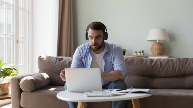Kablosuz kulaklıklı bir adam müvekkille bilgisayar iletişimine bakar ve video konferans uygulamasını uzaktan kullanmasına yardımcı olur. Dil becerilerini geliştirmek için eğitim, e-öğrenme, ses kursu