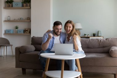 Çift dizüstü bilgisayar kullanıyor, e-posta okuyor, harika ticari teklif indirimi alıyor ve internetten tüm biletleri satıyor, piyangoyu kutluyor, açık arttırmayı kazanıyor, mutlu oluyor, çok mutlu görünüyor. Zafer anı, başarı, başarı konsepti