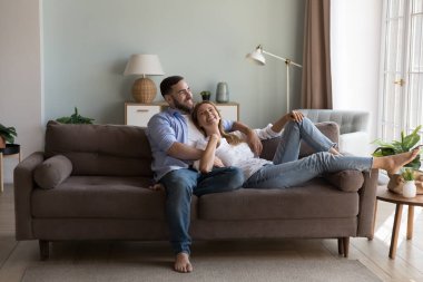Sevgi dolu rahat bir çift, şık oturma odasındaki kanepede dinlenmeyi, hayallerini paylaşmayı, geleceği ve çocukları planlamayı, modern evde vakit geçirmeyi sever. Hayaller, romantik ilişkiler, randevu kavramı