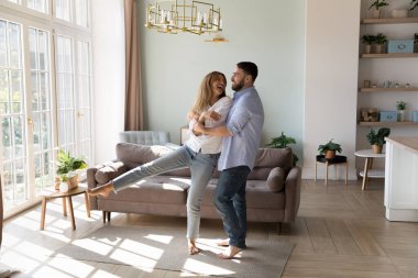 Eşler, son moda, güneşli oturma odasında çıplak ayakla müzik dinlerler. Mutlu ev sahipleri birbirine aşık çiftler romantik buluşmalardan hoşlanırlar. Yeni ev, genç aile konsepti için banka kredisi