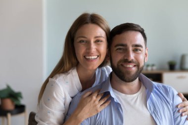 Kameraya poz veren sevgi dolu bir çift. Güzel bir kadın, sevgili kocasına sarılıyor kameraya bakıp sevgisini hissediyor. Sağlık eşlerinin portresi, aile kavramı için sağlık sigortası.