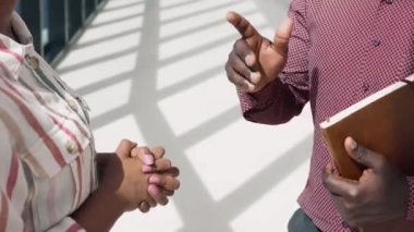 İki çok ırklı erkek, kadın takım arkadaşı konuşuyor, şirket çalışma alanında buluşuyorlar, karşılıklı saygı gösteriyorlar, başarılı bir ortaklık jesti, verimli ve etkili bir işbirliği, yakın görüş.