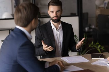 Yönetim kurulunda müzakere eden ciddi profesyoneller ekibi, proje tartışması, sözleşme şartlarını ve şartları düşünün, konferans odasındaki masada oturan işi çözün, resmi toplantıyı ofiste yapın.