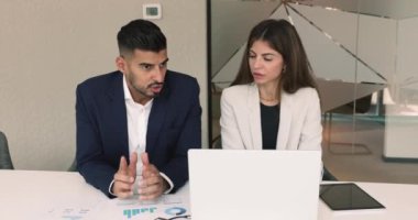 İki farklı proje ortağı bir dizüstü bilgisayarda konuşuyor, pazarlama stratejisini birlikte geliştiriyor, iş planını tartışıyor, iş yerinde beyin fırtınası yapıyor, bilgisayar başında oturuyor.