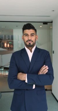 Kendine güvenen genç Hintli iş adamı dikey video portresi. Pozitif iş adamı, yönetici, şirket yöneticisi elleri bağlı poz veriyor, kameraya bakıyor, mutlu oluyor.