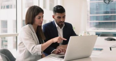 Çevrimiçi proje yönetiminde birlikte çalışan çeşitli iş adamları, dizüstü bilgisayarda birlikte yazma, İnternet içeriğini tartışma, satış hizmeti, iş başvurusu, ekrana işaret etme, konuşma