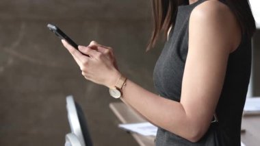 Yeni cep telefonu uygulaması kullanarak, mesajları paylaşarak, sohbetin keyfini çıkararak, e-posta yazarak ya da cep telefonuyla kablosuz internet tarayarak modern akıllı telefon kullanan iş kadınının kırpılmış görüntülerini kapatın.