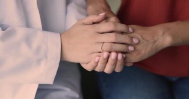 Kadın hastanın elini tutan genç doktor, sempati, psikolojik destek, tıbbi tavsiye, danışma, ciddi kötü teşhis ve zor tedavi konularını tartışıyor.