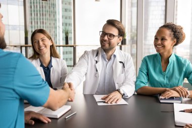 Bir grup tıp uzmanı ve sağlık çalışanı modern gökdelen ofisindeki konferans odasında toplanarak hasta tedavi planı konusunda anlaşmaya vardılar. İşbirliği ve ortaklık