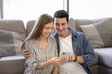 Latin karı ve kocanın cep telefonu uygulamasını birlikte kullanması, akıllı telefona bakması, internete bakması, sosyal medyaya bakması, kucaklaması, gülümsemesi, gülmesi, sanal kablosuz teknolojiden hoşlanması.