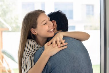 Mutlu, genç bir eş, kapalı gözlü kocaya sarılıyor, erkeklerin boynunu sevgiyle kucaklıyor, gülümsüyor, gülüyor, eğleniyor, heyecanlanıyor, eğleniyor, eğleniyor, özel bir etkinliği kutluyor.