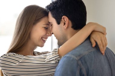 Mutlu genç çift burunlarıyla sarılıyor, gülüyor, birlikte dans ediyor, flört ediyor, romantik bir olay, romantizm, sevgililer gününü kutluyor, evlilik yıldönümünü kutluyor.