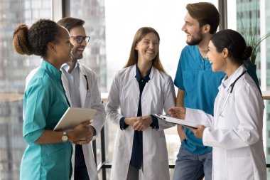 Bir grup hemşire, doktorlar klinikte toplandılar, güldüler, ara verdiler, brifing verdiler, şakalaştılar, mutlu görünüyorlardı, iş gününden önce arkadaşça sohbete katıldılar. İşbirliği