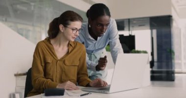 İşbirliği yapan, tartışmalara giren, hesaplamalar, veri analizi veya finansal planlamayı içeren ortak görevler üzerinde birlikte çalışan iki kadın meslektaşı çağdaş ofiste bir araya geldi. Takım çalışması, muhasebe