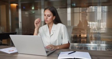 Laptop üzerinde çalışan, mali rapor veya sunumu gözden geçiren, veri veya mali istatistikleri analiz eden, yazı, düzenleme belgesi hazırlayan, iş teklifi hazırlayan veya güncelleyen Kafkasyalı iş kadını