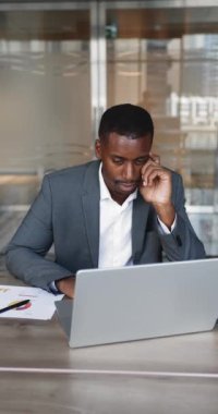 Laptop üzerinde çalışan odaklanmış Afrikalı erkek çalışanlar, çevrimiçi proje için finansal hesap tablolarını veya bütçeleri incelemek, raporu incelemek, araştırma, yeni iş yapay zekası araçları veya yazılım uygulamalarını öğrenmek