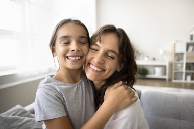 Yüzlerinizi kapatın neşeli güzel anne ve küçük kız kucaklaşıyorlar, yanaklara dokunuyorlar, gülümsüyorlar, hassas anların tadını çıkarıyorlar, bağlantı kuruyorlar, yakın ilişki yaşıyorlar, evde boş zaman geçiriyorlar. Annelik, bağlar