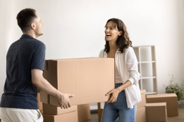 Uzun süreli bir daireye taşınıp, birlikte yaşamaya başlayıp, kişisel eşyalarını büyük karton kutulara doldurup, gülerek mutlu olan gülen çiftler. Mülk alıcıları, genç aile için kredi